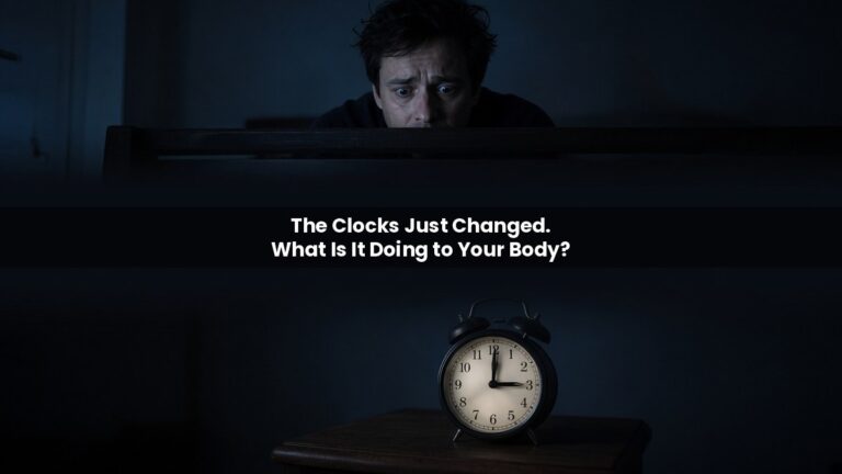 Exhausted man staring at an alarm clock at 3am in a dark bedroom after the clocks change